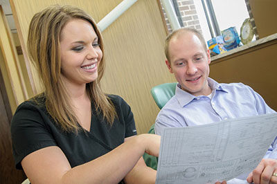 dh Dental care hygienist Jessi with patient reviewing post op instructions