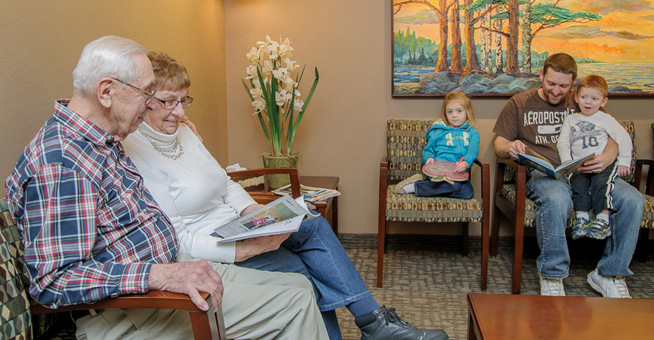 Patients in waiting room looking throught patient information.